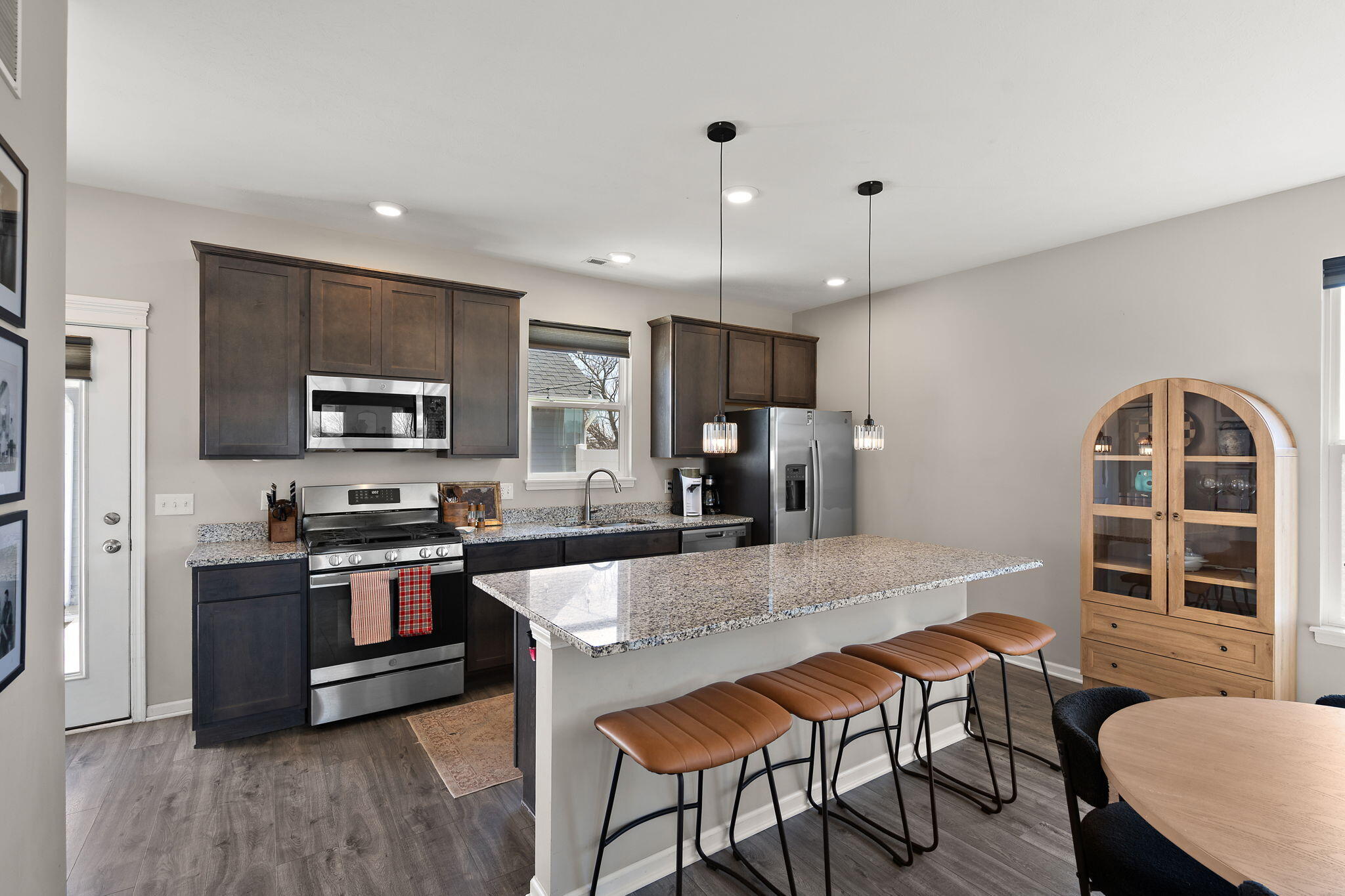 11897 Rhode Island Street Crown Point, IN 46307 - Photo 8 of 21 a kitchen with stainless steel appliances granite countertop a stove top oven a sink dishwasher a dining table and chairs with wooden floor