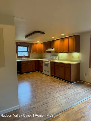 a view of kitchen with stainless steel appliances granite countertop a sink and stove top oven
