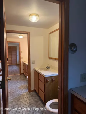 a bathroom with a toilet a sink and mirror