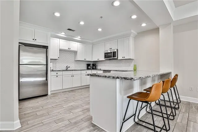 a kitchen with stainless steel appliances kitchen island granite countertop a refrigerator sink and cabinets