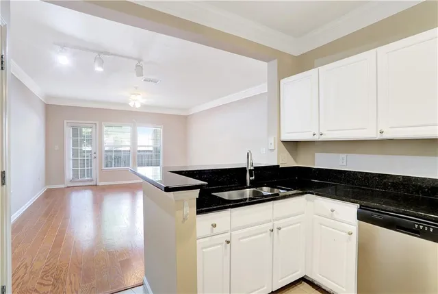 a kitchen with granite countertop white cabinets and a stove