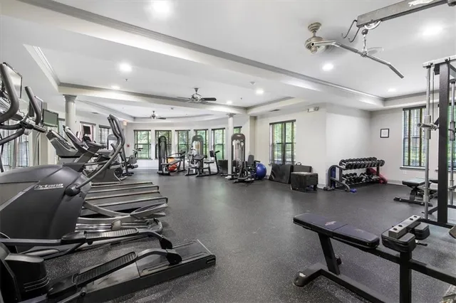 a gym room with lots of chairs and mirrors