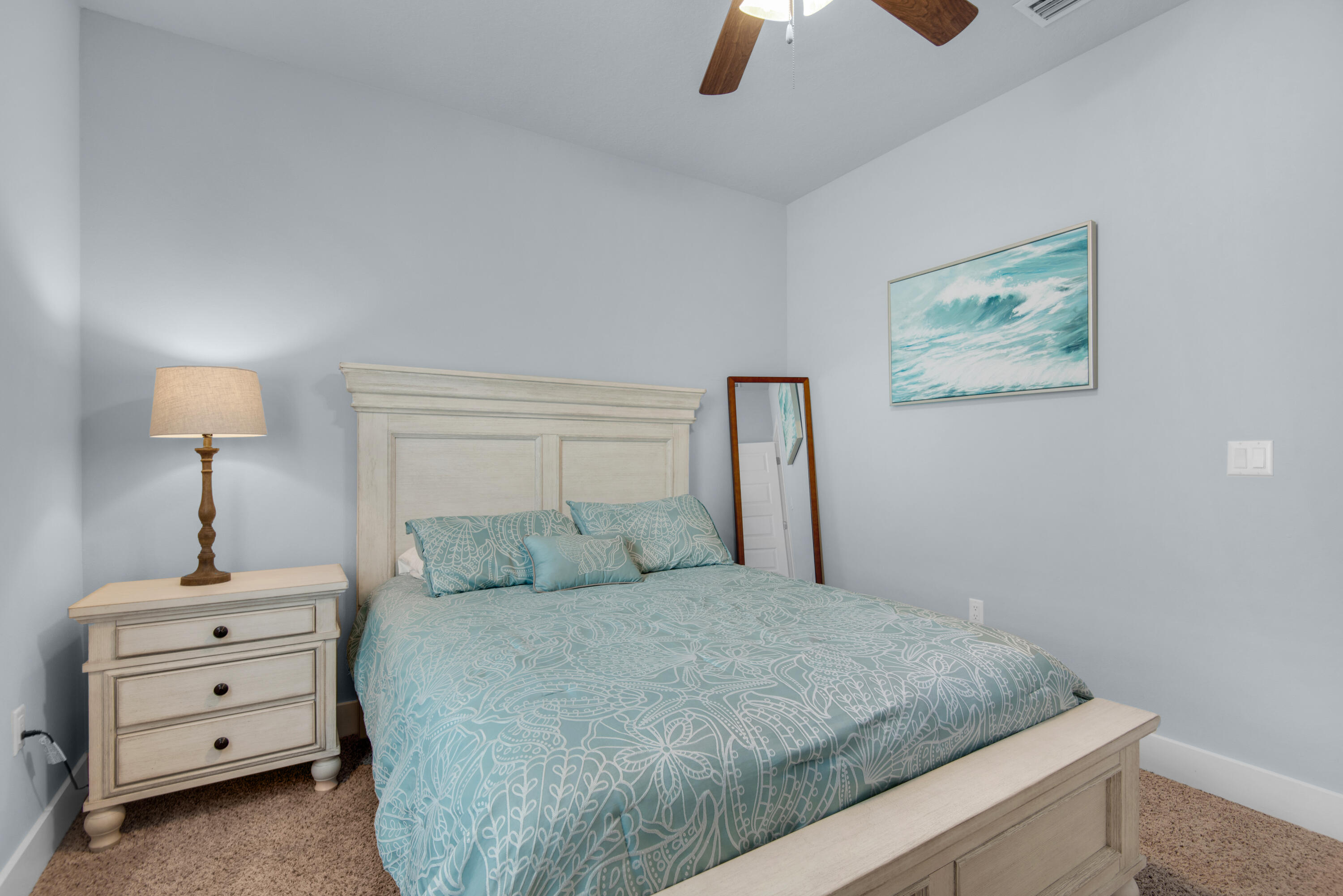 1494 Seaside Circle Navarre, FL 32566 - Photo 30 of 69 a bedroom with a bed and a lamp on the dresser