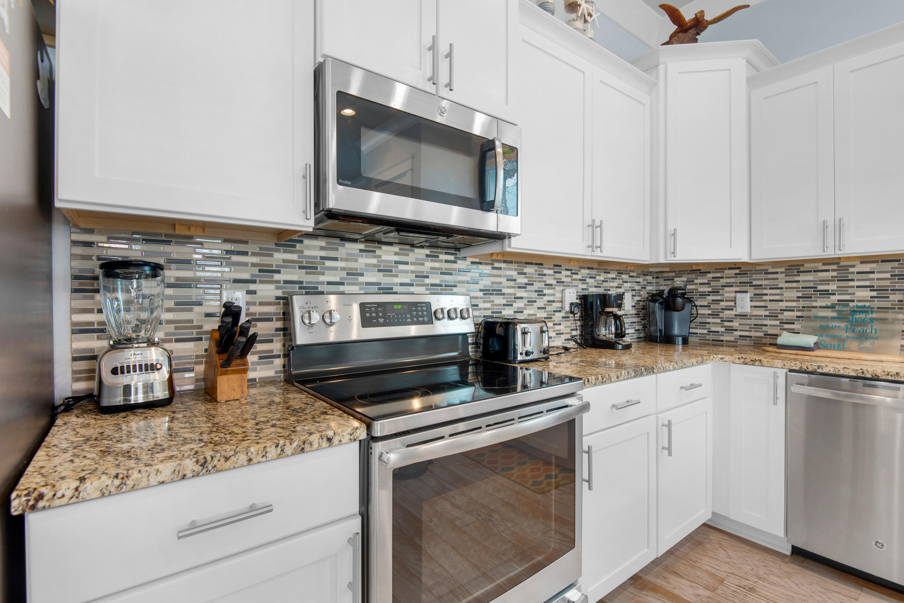 1494 Seaside Circle Navarre, FL 32566 - Photo 4 of 69 a kitchen with stainless steel appliances granite countertop a sink stove and microwave