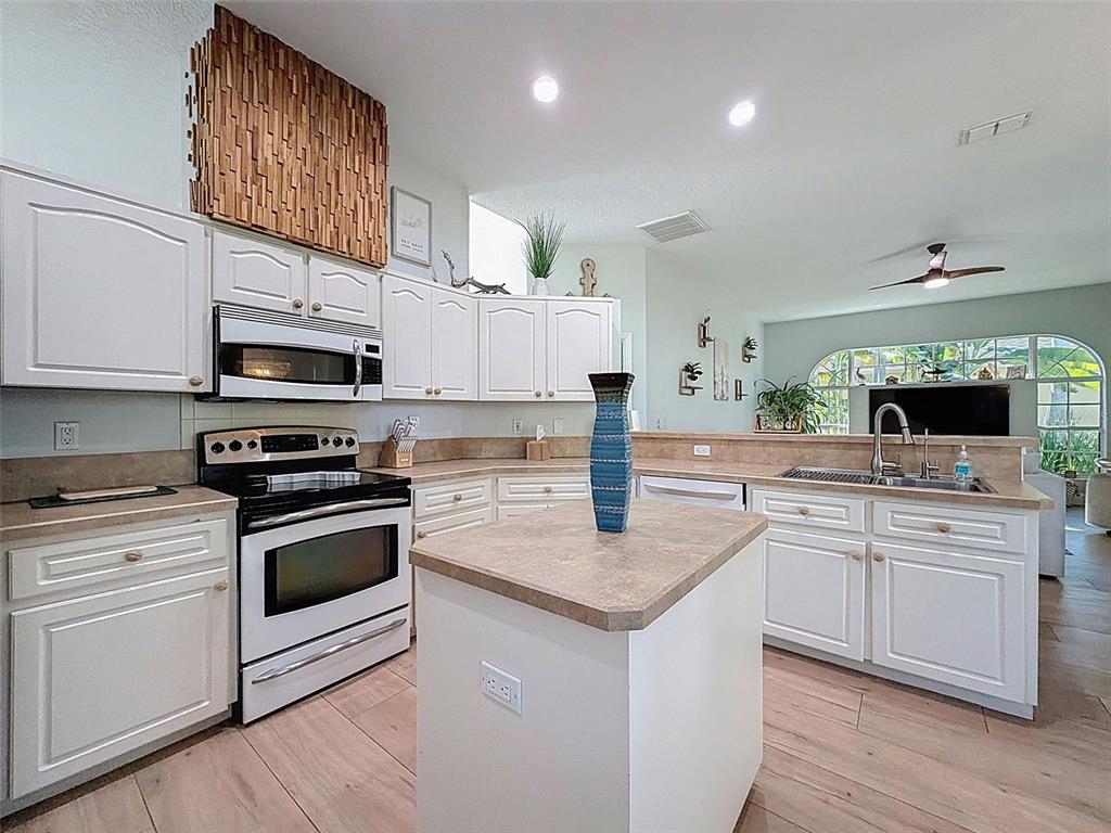 3365 Indian River Street Spring Hill, FL 34609 - Photo 11 of 38 a kitchen with stainless steel appliances granite countertop a sink stove and refrigerator