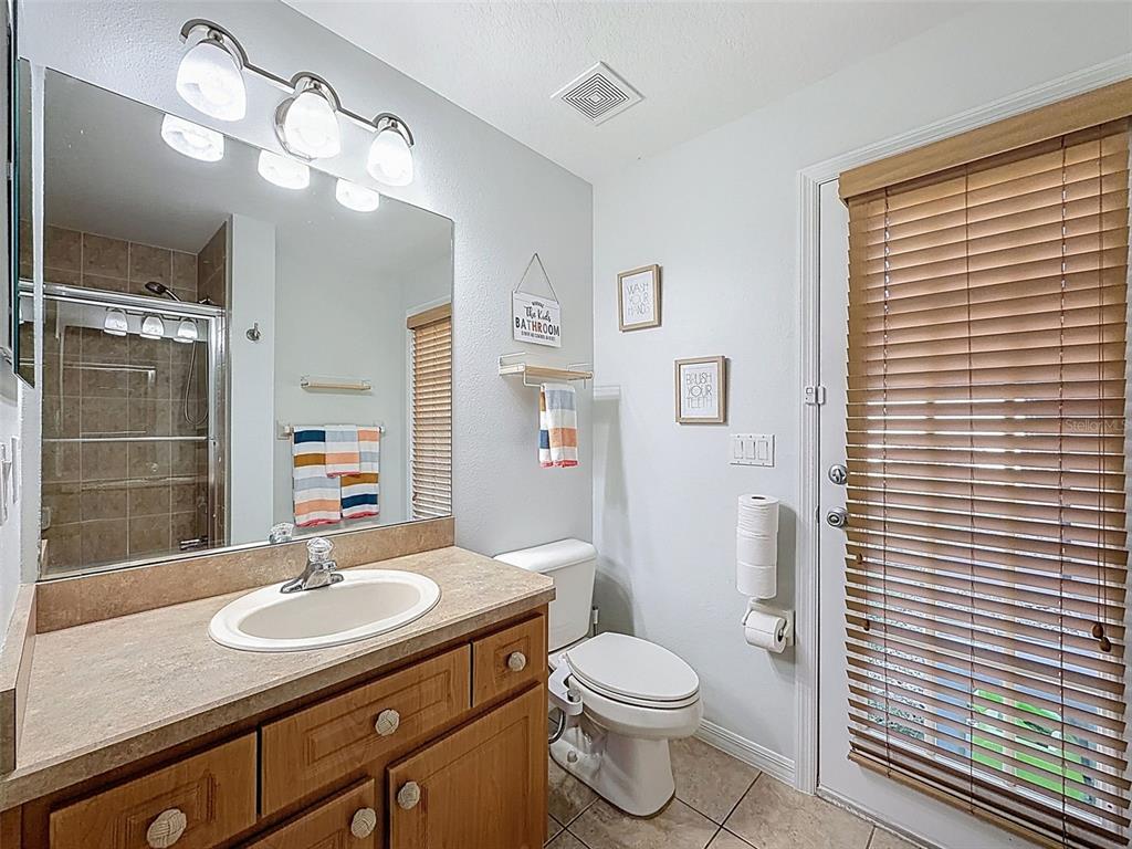 3365 Indian River Street Spring Hill, FL 34609 - Photo 26 of 38 a bathroom with a sink a toilet a mirror and shower curtain