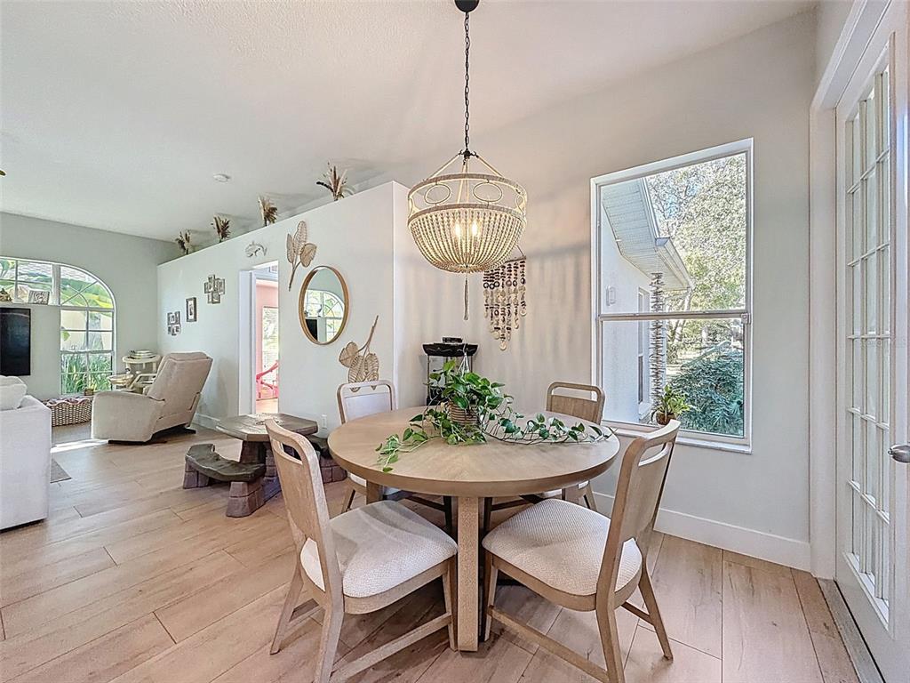 3365 Indian River Street Spring Hill, FL 34609 - Photo 9 of 38 a dining room with furniture a chandelier and wooden floor