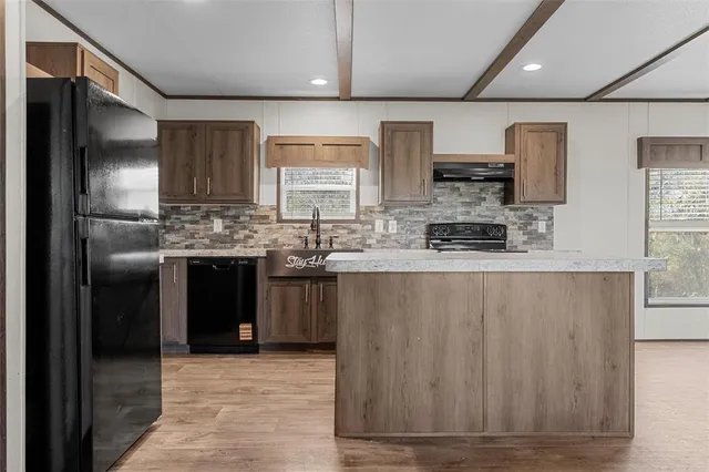 a kitchen with stainless steel appliances granite countertop a stove a sink and a refrigerator