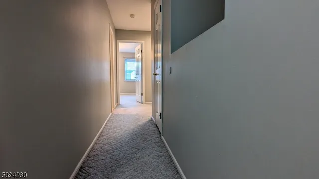 a view of a hallway with wooden floor and a door