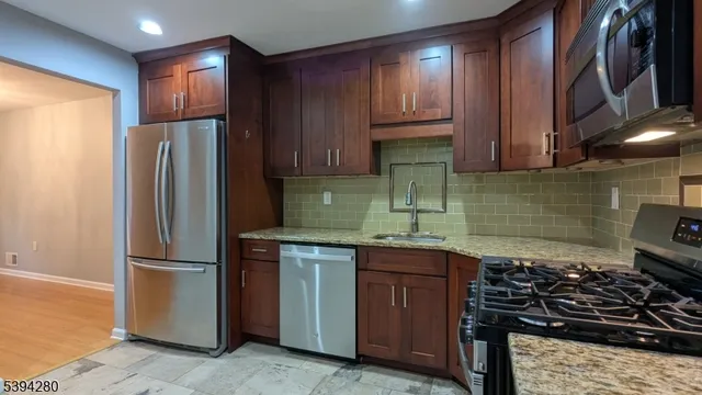 a kitchen with stainless steel appliances granite countertop a refrigerator and a sink