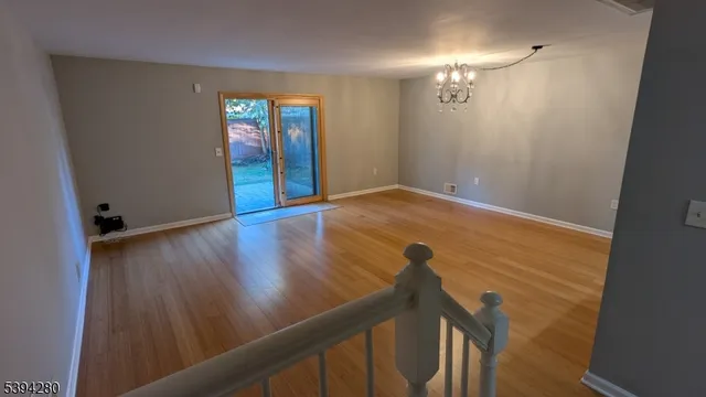 a view of a hallway with wooden floor and stairs