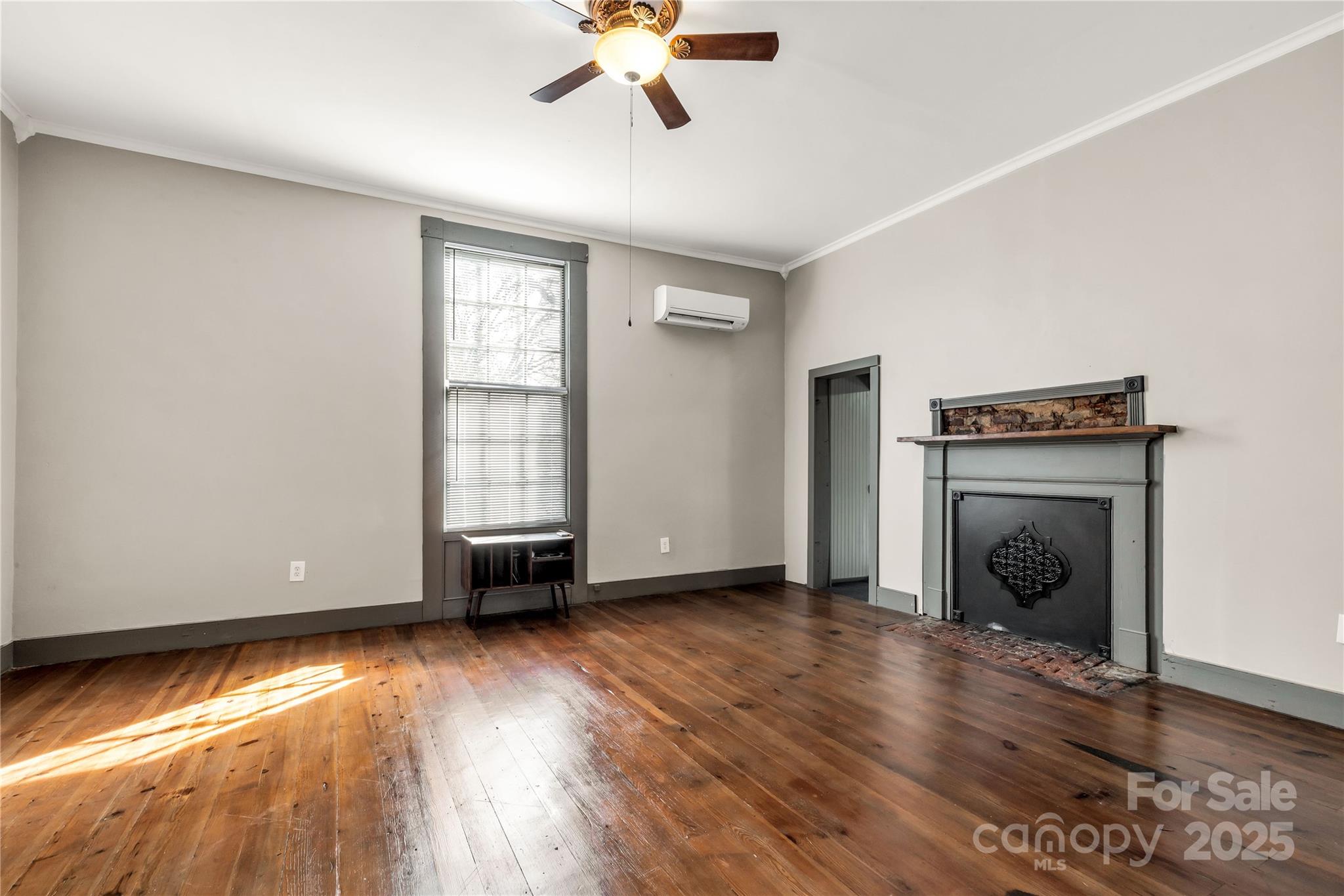 226 Liberty Street East York, SC 29745 - Photo 34 of 48 an empty room with wooden floor fireplace and windows