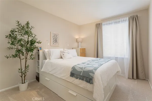 a bedroom with a bed and a potted plant