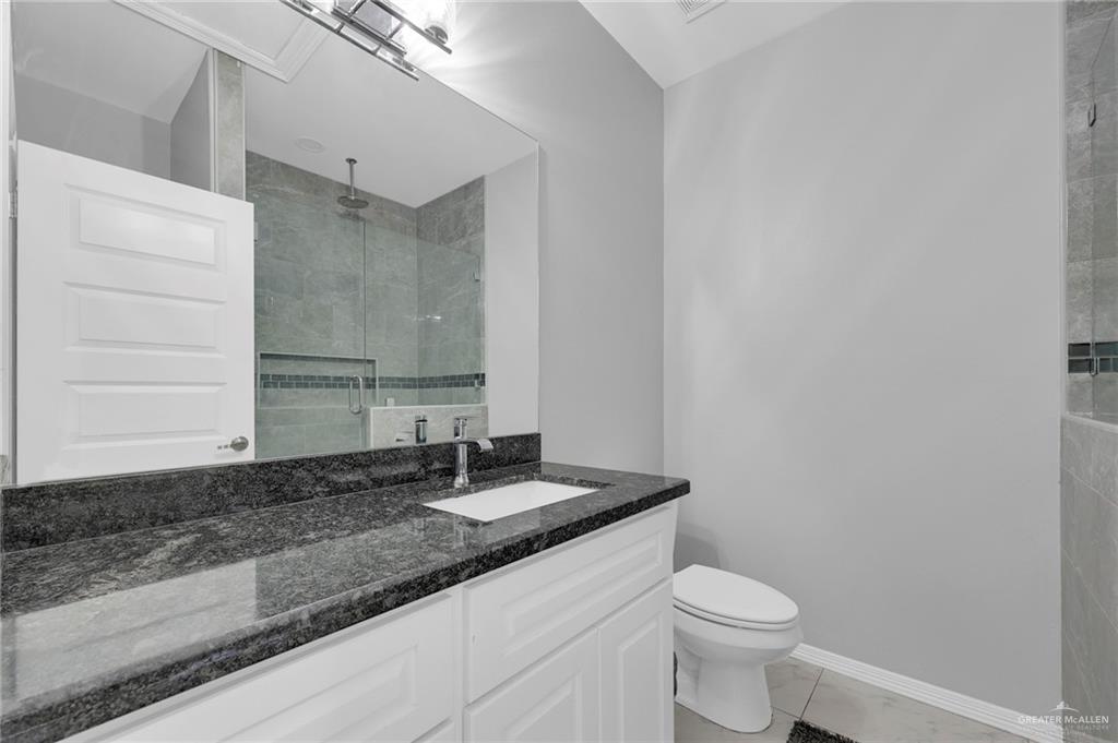 502 Oak Ridge Street Donna, TX 78537 - Photo 13 of 28 a bathroom with a granite countertop sink and a toilet