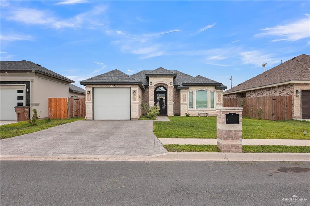 502 Oak Ridge Street Donna, TX 78537 - Photo 3 of 28 a front view of a house with a yard and garage