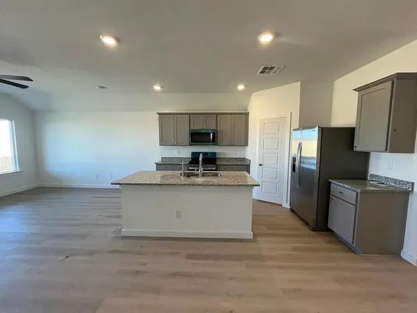 a view of kitchen with refrigerator microwave and stove