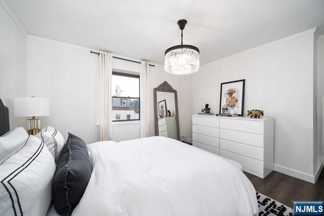 141 Park Avenue, Unit 8A East Rutherford, NJ 07073 - Photo 15 of 22 a bedroom with a bed and a chandelier