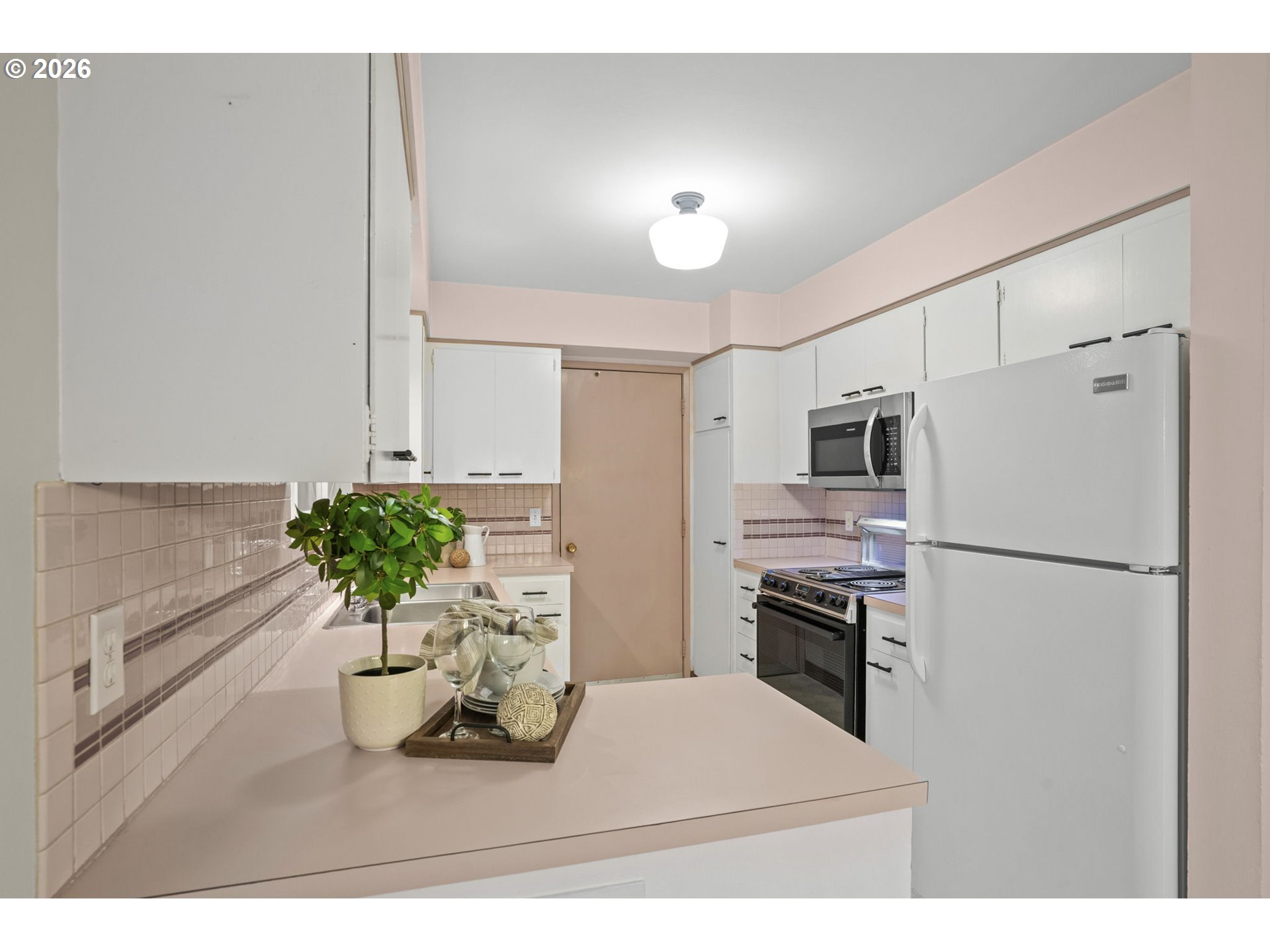 10531 Southeast Long Street Portland, OR 97266 - Photo 11 of 42 a kitchen with refrigerator a microwave and cabinets