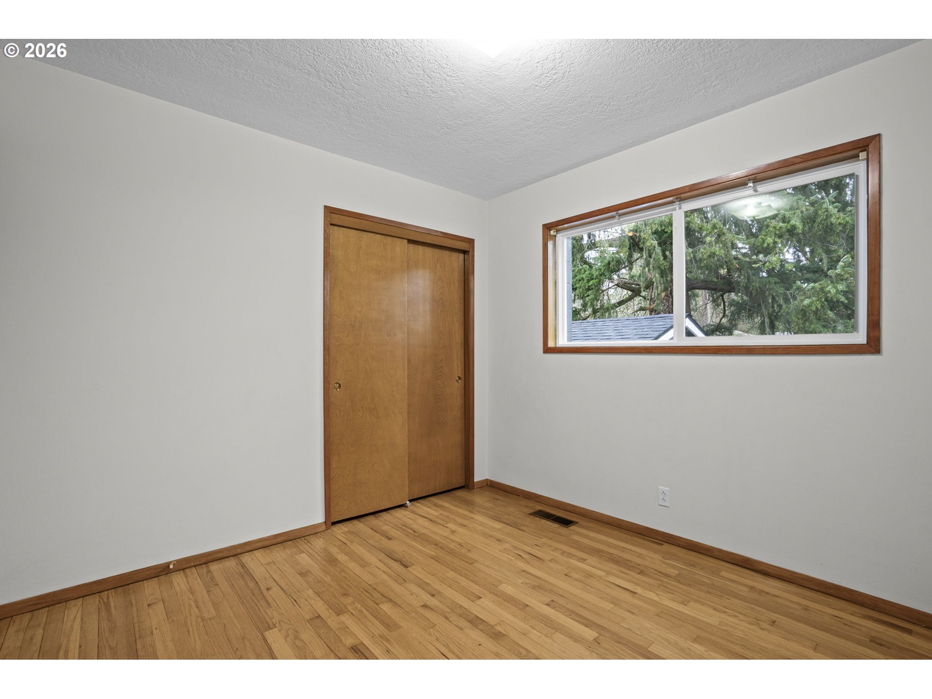 10531 Southeast Long Street Portland, OR 97266 - Photo 21 of 42 an empty room with wooden floor and windows