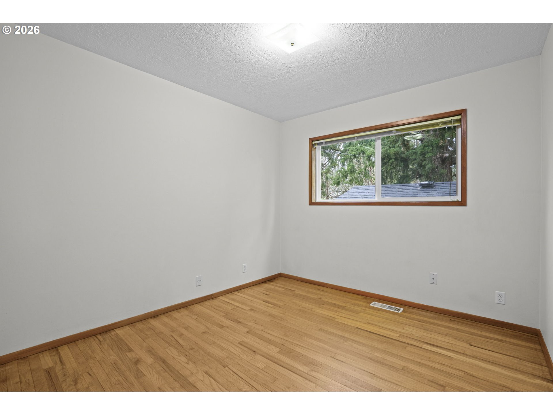 10531 Southeast Long Street Portland, OR 97266 - Photo 23 of 42 an empty room with wooden floor and painting on the wall