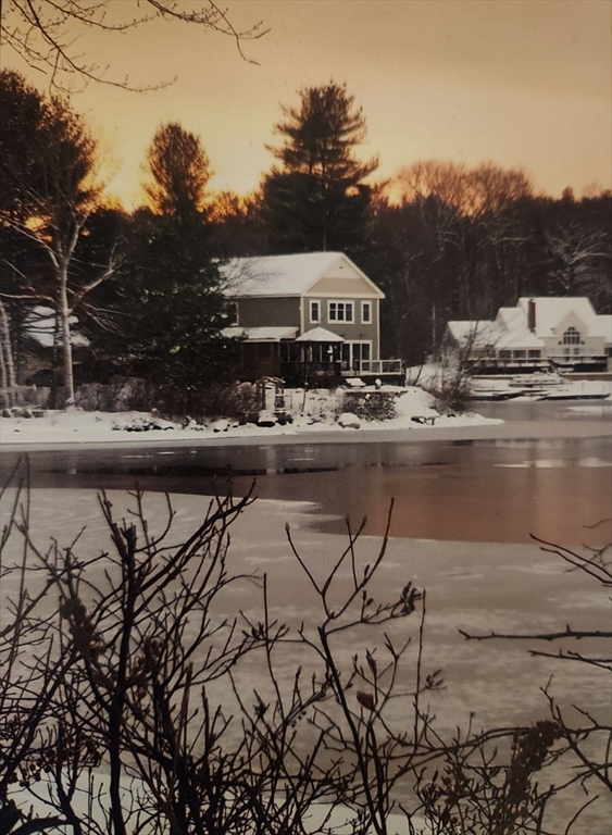 15 Grove Point Road Wales, MA 01081 - Photo 2 of 43 a view of a lake with lawn chairs under an umbrella