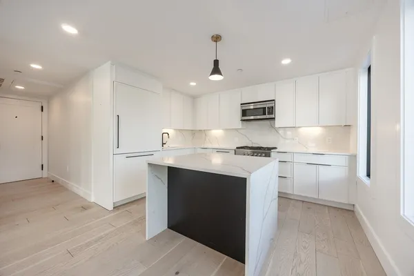 a kitchen with a refrigerator and a stove top oven