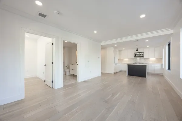 a large white kitchen with a sink and white cabinets