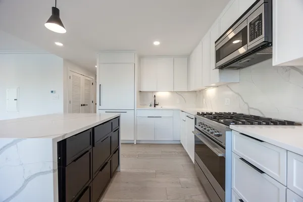 a kitchen with a stove sink and cabinets