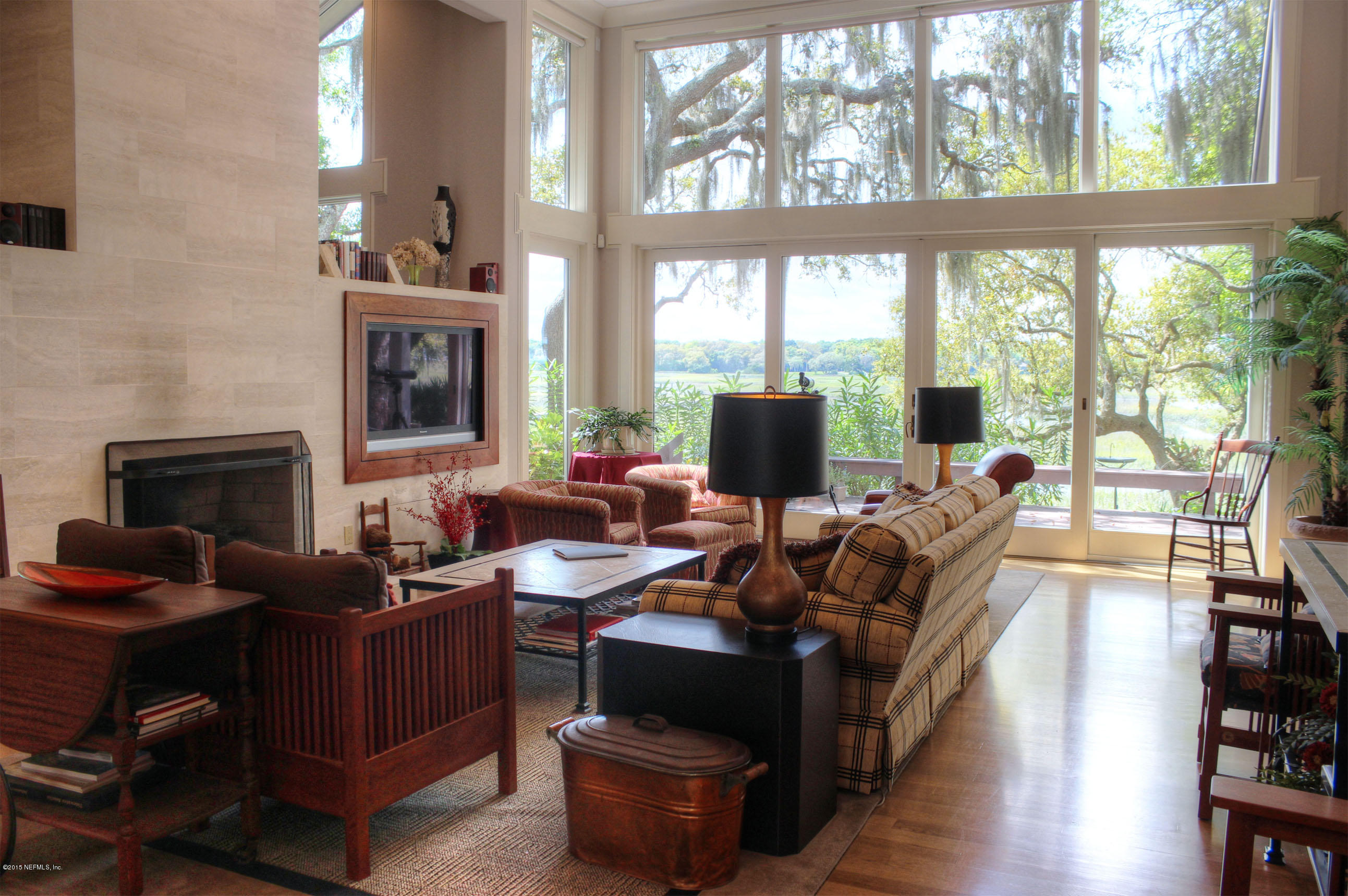 22 Sea Marsh Road Fernandina Beach, FL 32034 - Photo 3 of 24 a living room with furniture a fireplace and a floor to ceiling window