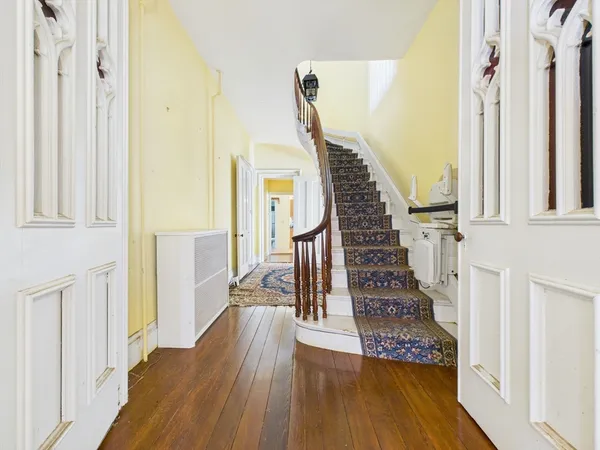 a view of a hallway with wooden floor and staircase