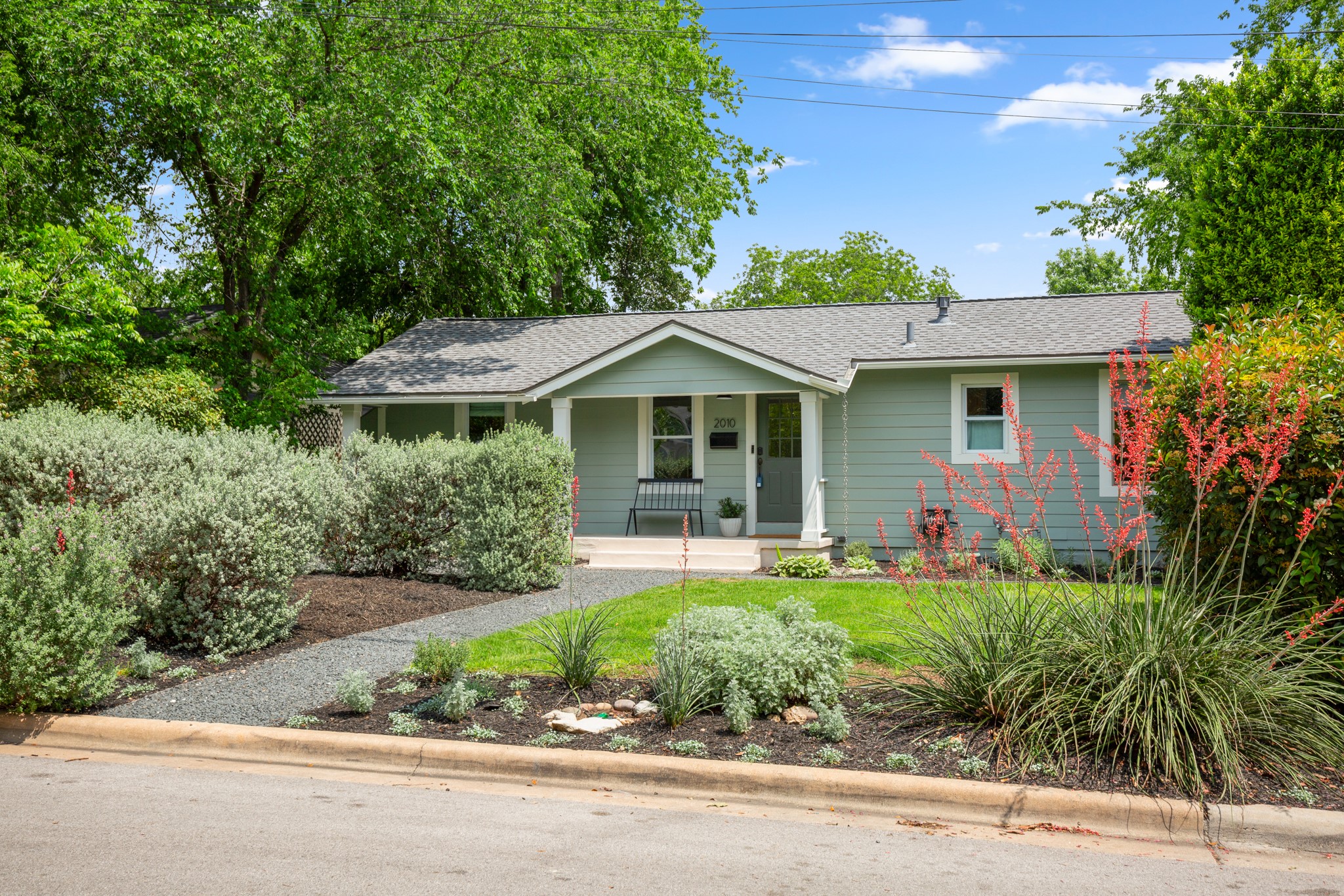 Single-story residence featuring light green siding and a covered front porch