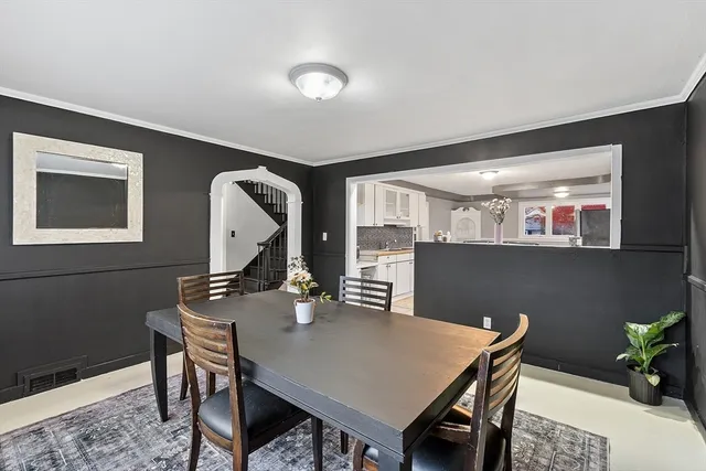 a view of a dining room and livingroom with furniture wooden floor a rug and a painting