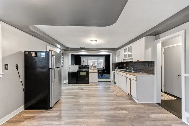 a large kitchen with a large counter top stainless steel appliances and cabinets