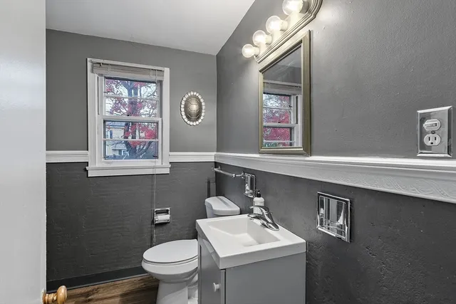 a bathroom with a toilet a sink and mirror