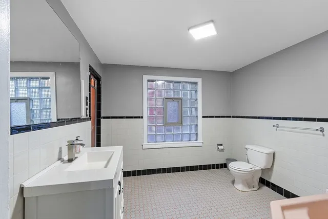 a bathroom with a sink toilet mirror and tub