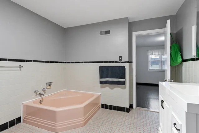 a bathroom with a tub and mirror