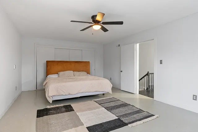 a bedroom with a bed and a ceiling fan