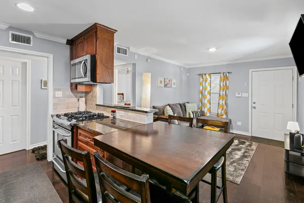 a kitchen with a stove a refrigerator and wooden floor