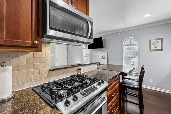 a kitchen with a stove a microwave and wooden cabinets