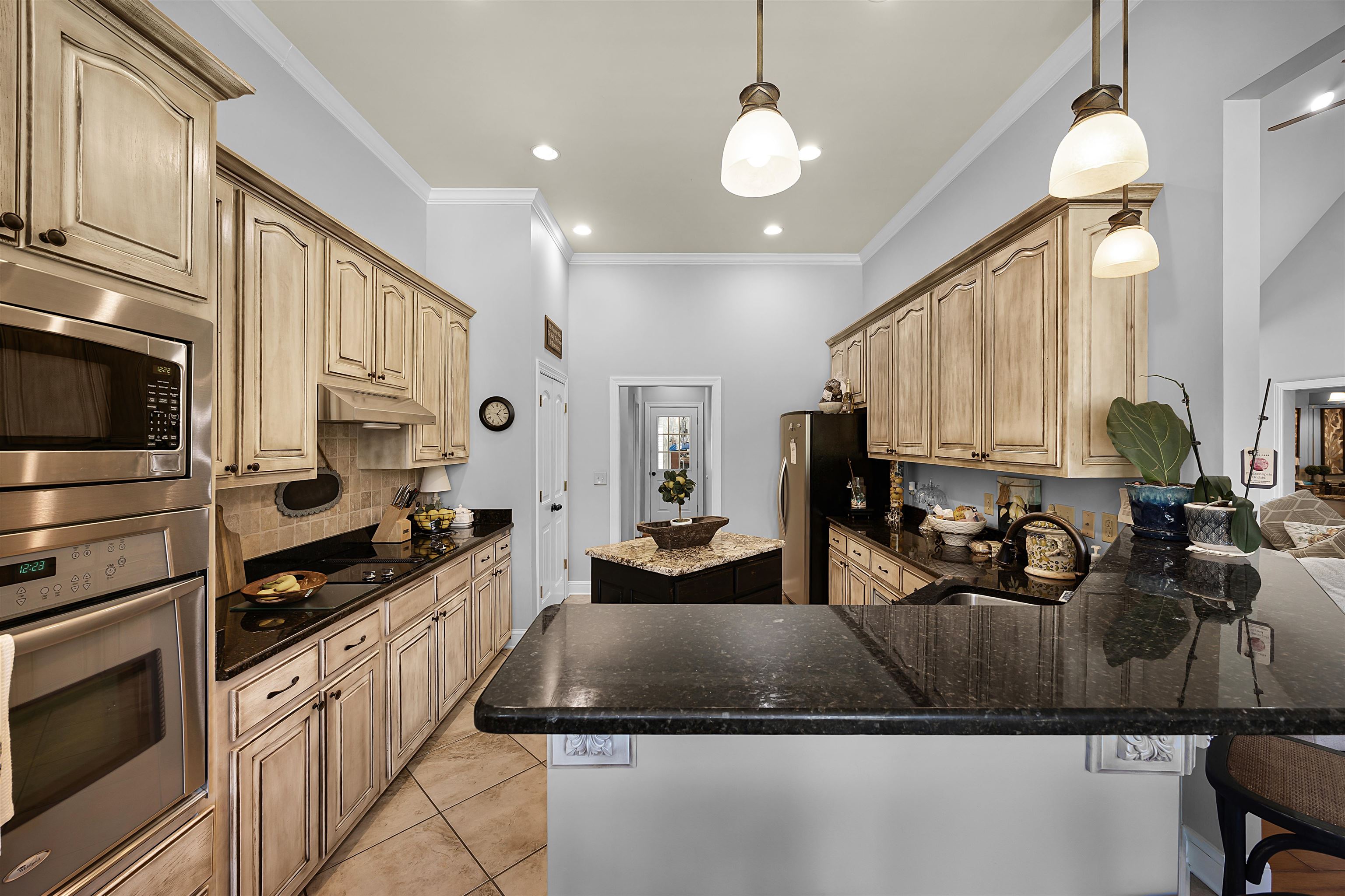140 Legends Drive Counce, TN 38326 - Photo 10 of 30 Kitchen featuring appliances with stainless steel finishes, decorative light fixtures, a center island, ornamental molding, and decorative backsplash