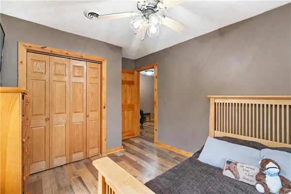 an empty room with wooden floor closet and windows