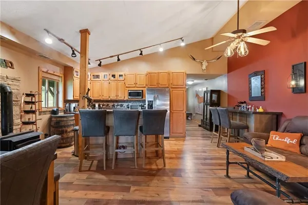 a living room with furniture a dining table and chairs with wooden floor