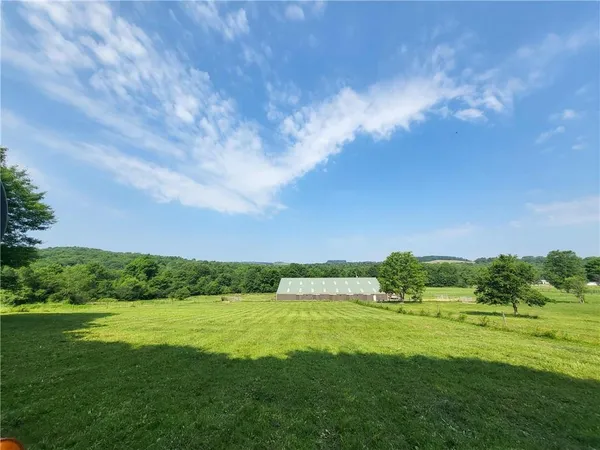 a view of a green field with wooden fence