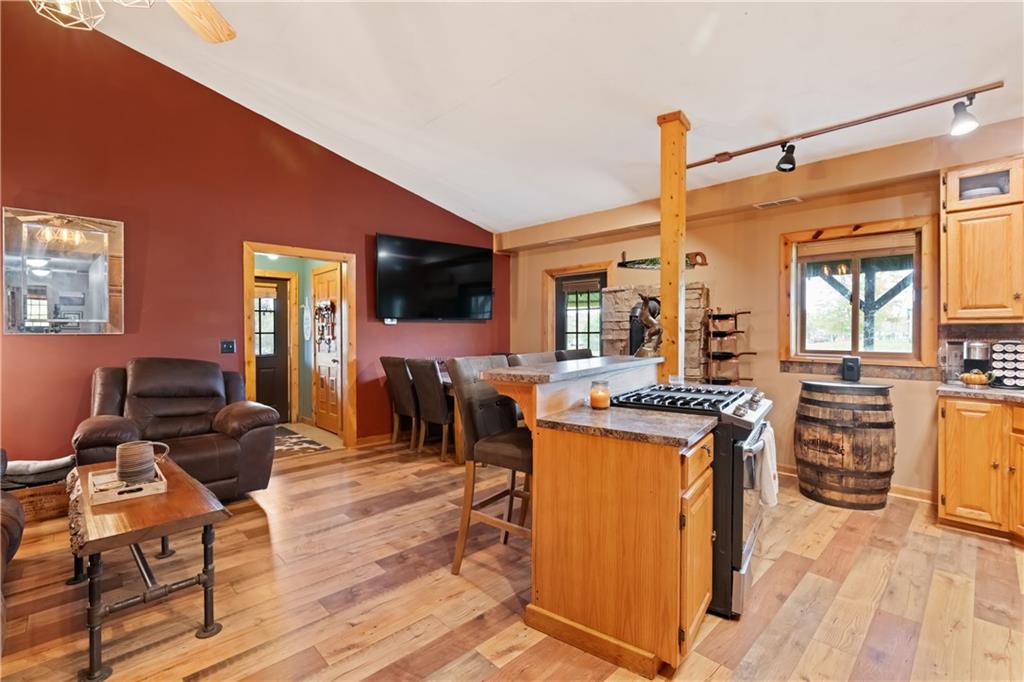 1316 Porter Road Harrisville, PA 16038 - Photo 4 of 37 a kitchen with stainless steel appliances granite countertop a stove top oven a refrigerator a dining table and chairs with wooden floor