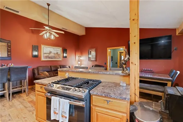 a kitchen with a stove and a flat screen tv