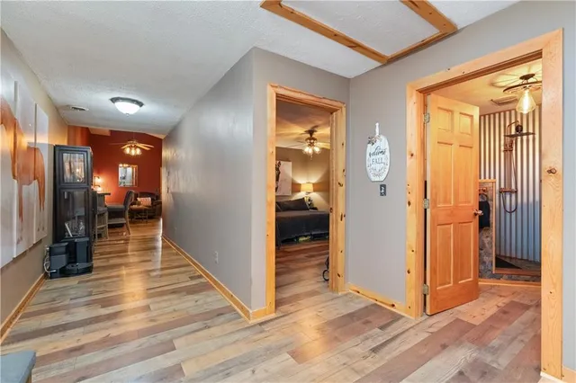a view of a hallway with wooden floor and a living room