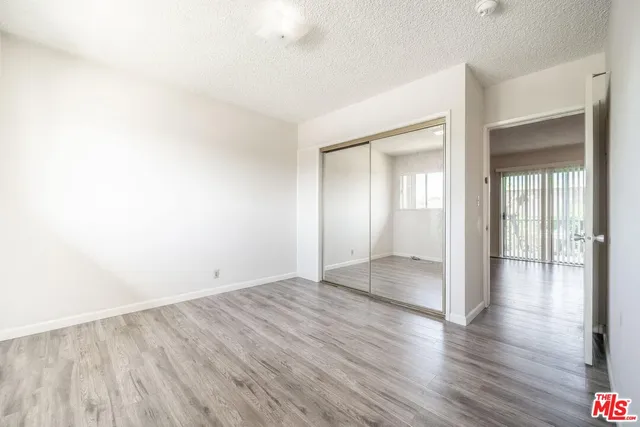 an empty room with wooden floor & windows