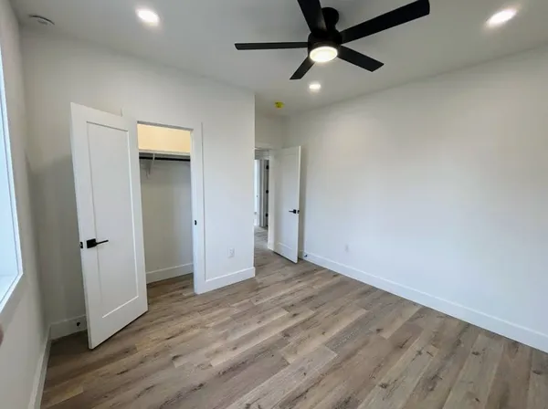 a view of a hallway with wooden floor and entryway