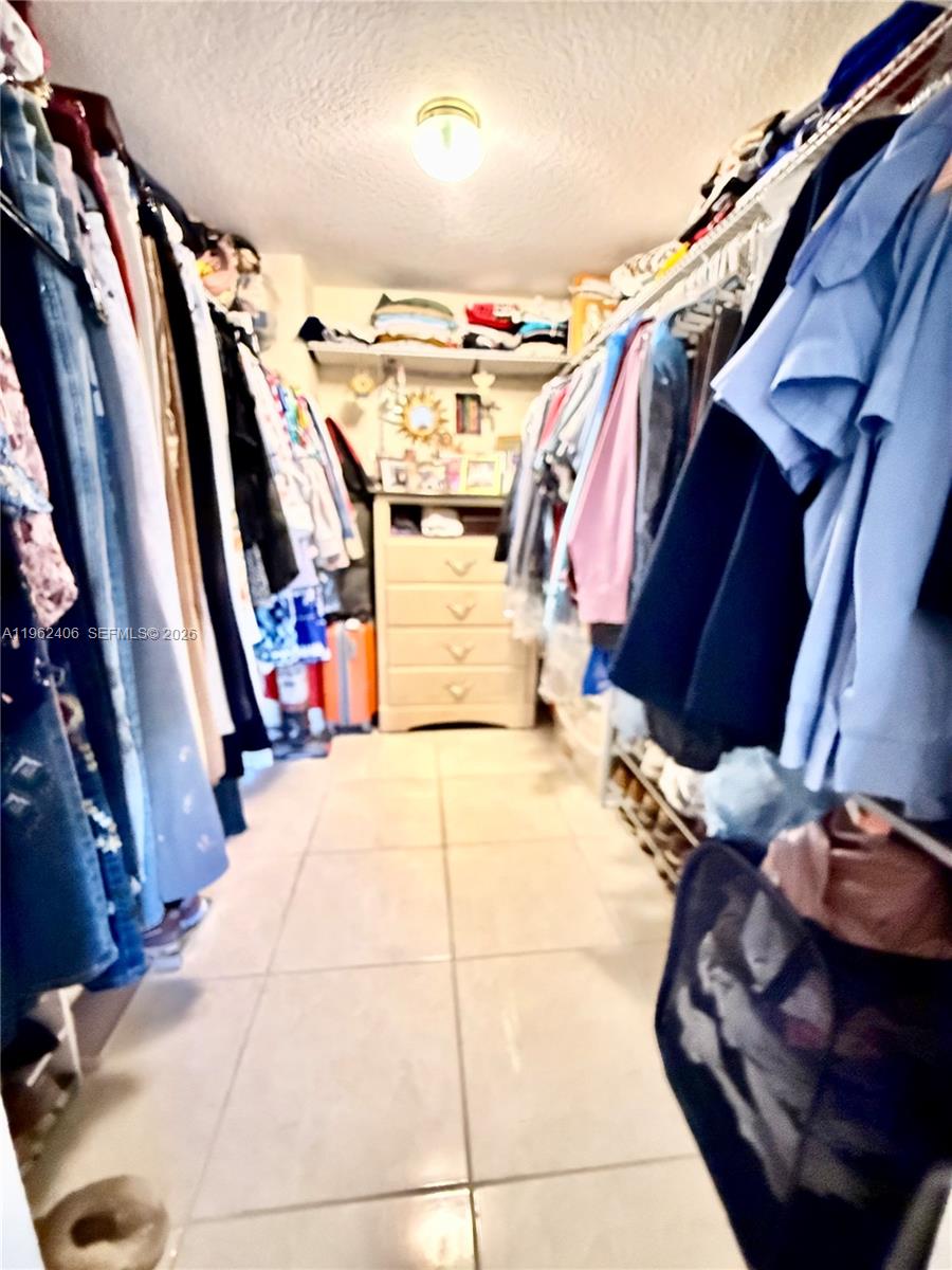 351 Club Circle, Unit 102 Boca Raton, FL 33487 - Photo 26 of 34 a view of walk in closet with clothes and shoes