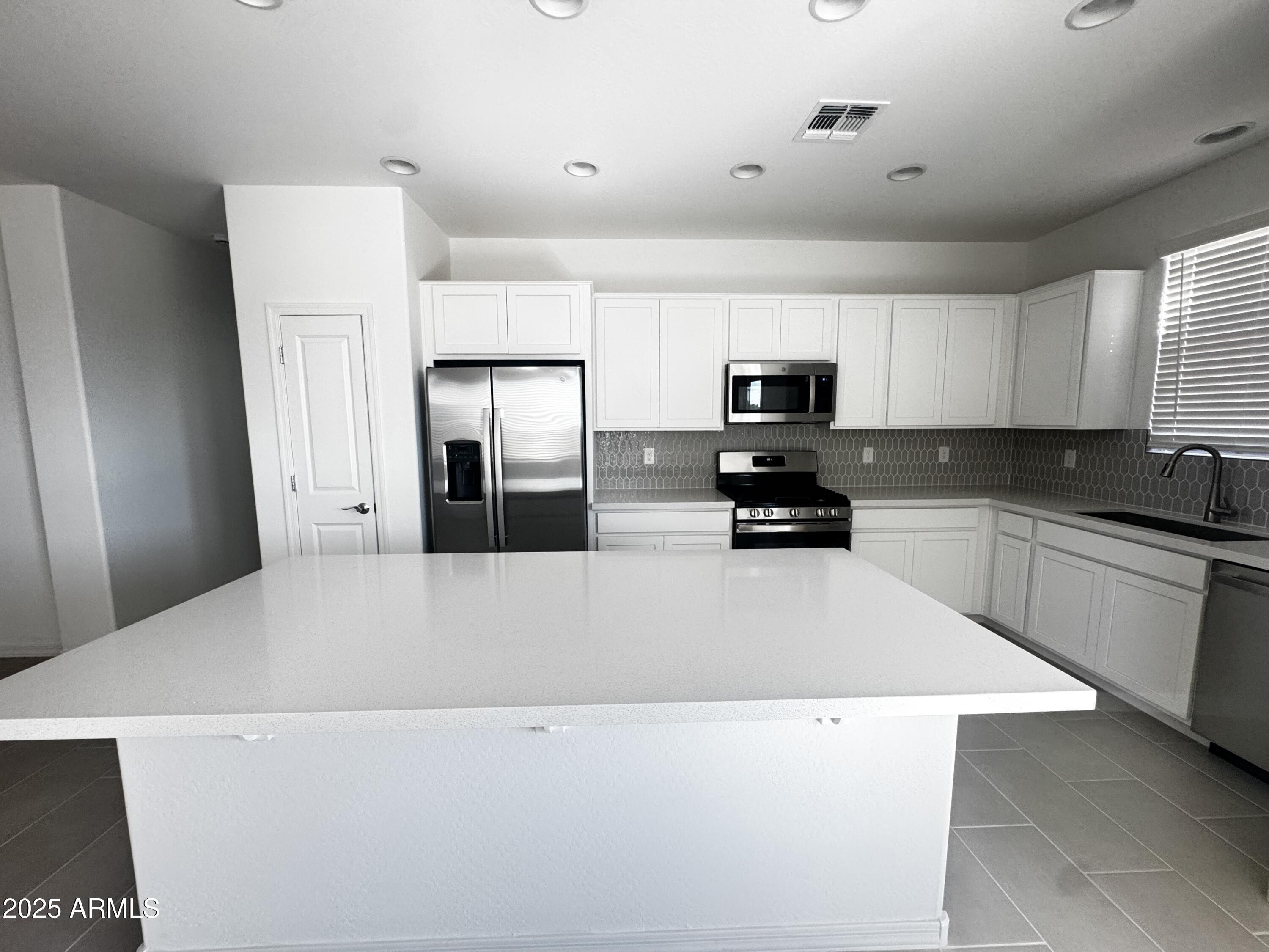 a kitchen with a refrigerator and a stove top oven